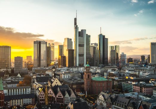 The Frankfurt city surrounded by buildings under a cloudy sky during a golden sunset in Germany